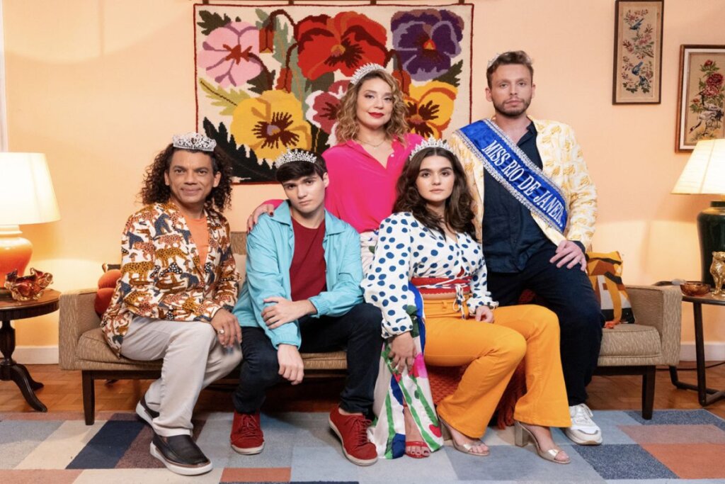 Atores do filme "A Miss" sentados em um sofá em uma sala de estar 