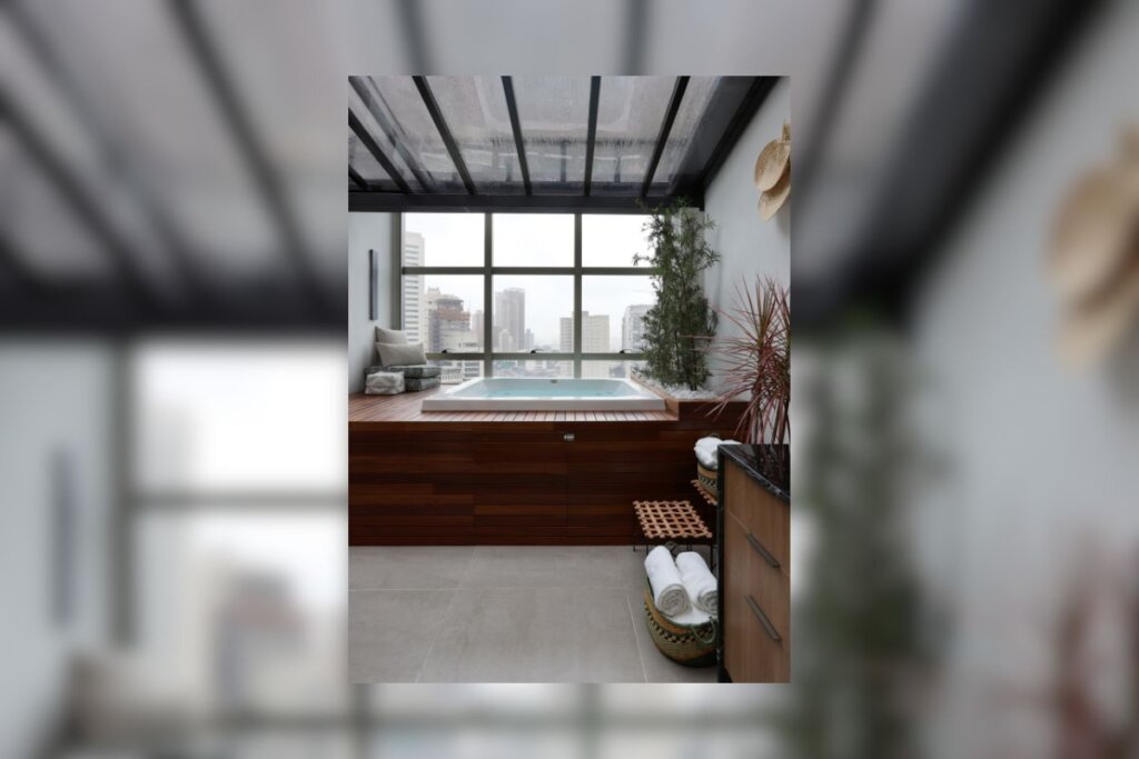 Banheira em área externa com cobertura de vidro