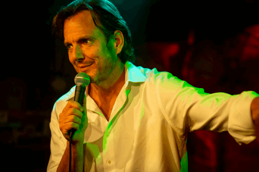 Homem segurando microfone em palco iluminado com luz verde durante apresentação