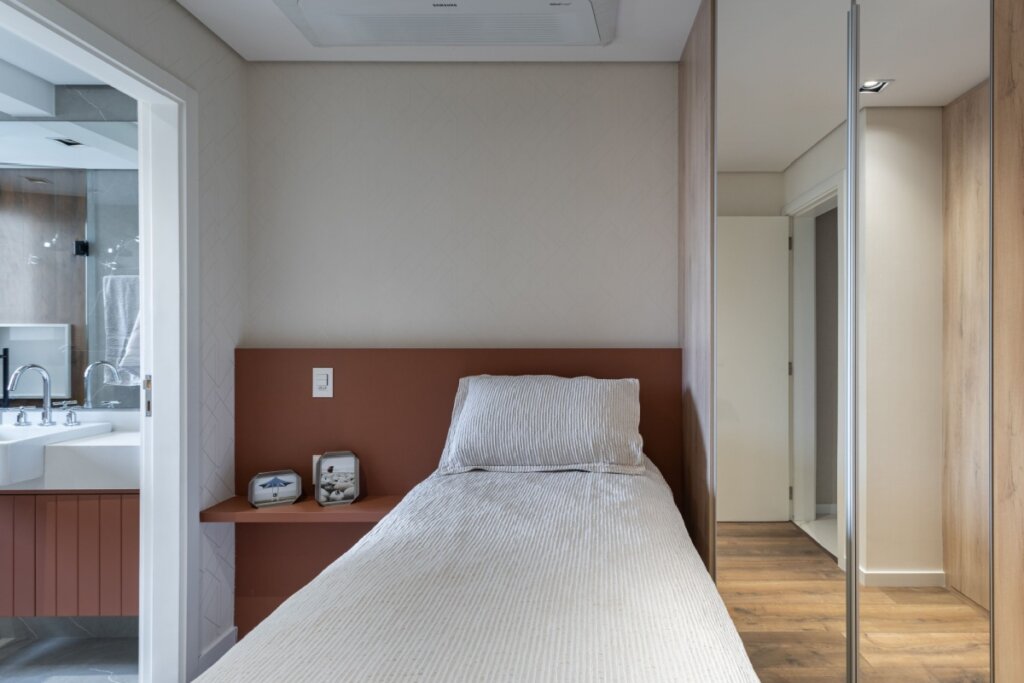 Esta imagem de uma cozinha moderna com painel de madeira. A bancada da cozinha e a ilha de refeições apresentam superfícies de madeira de tábuas horizontais. O rack de vinho e as prateleiras abertas acima da bancada são feitos de madeira e metal. Um painel de madeira com veios horizontais reveste uma das paredes laterais, criando uma sensação de calor e continuidade.