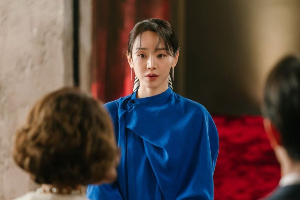 Cena da protagonista de "A Arte de Sarah" em pé e usando roupa azul 