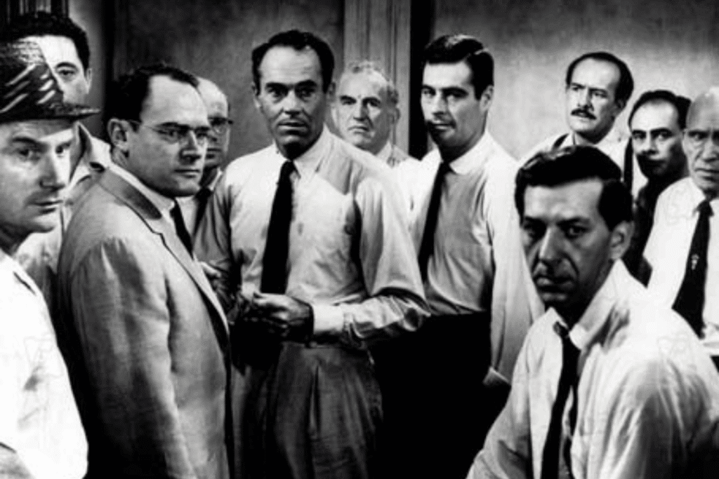 Uma fotografia em preto e branco com um grupo de homens em uma sala, enquadrados do peito para cima. Eles vestem camisas sociais, gravatas e paletós da época. Com fisionomias sérias e preocupadas, a maioria deles olha fixamente na mesma direção, em um ambiente de forte tensão e concentração.