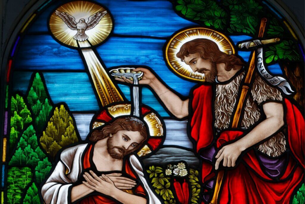 Vitral com a imagem de João Batista batizando Jesus com um cálice de água 